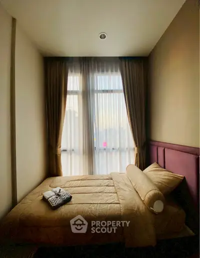 Cozy bedroom with large window and elegant curtains, perfect for relaxation and comfort.