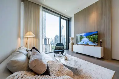 Luxurious modern living room with city view, elegant decor, and large TV