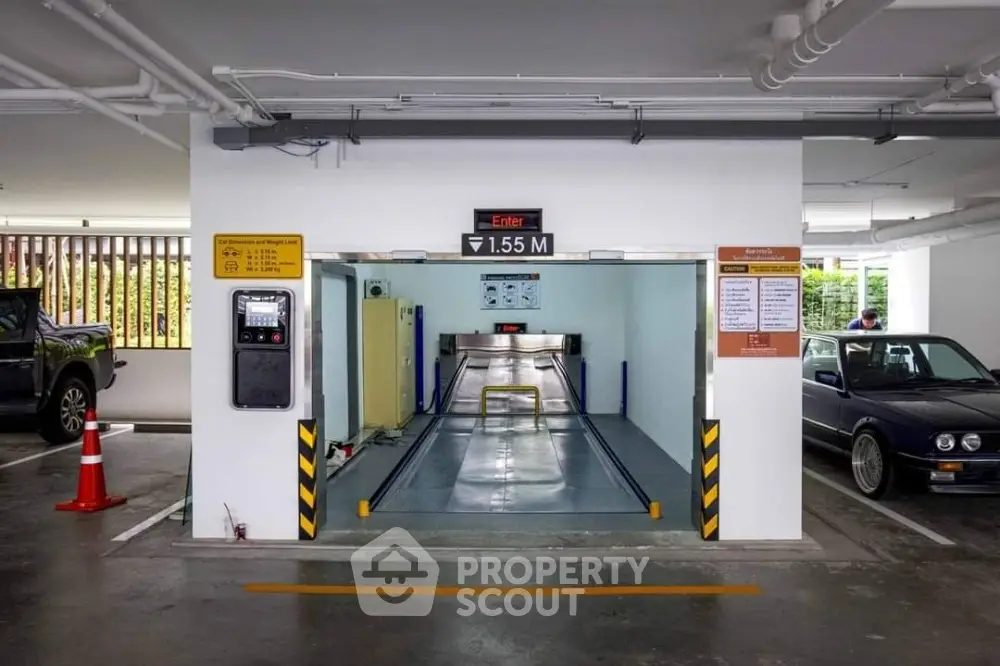 Modern parking garage with automated car lift system and clear signage.