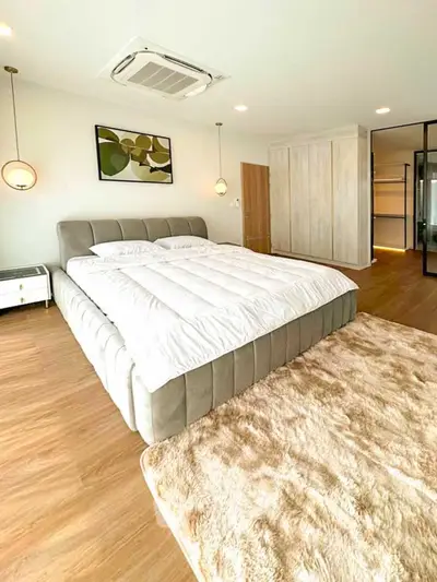 Luxurious bedroom with plush bed and modern decor, featuring elegant lighting and spacious design.