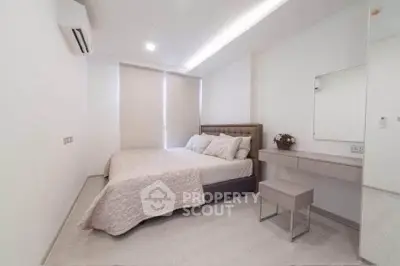 Modern minimalist bedroom with sleek design and neutral tones, featuring a cozy bed and stylish vanity.