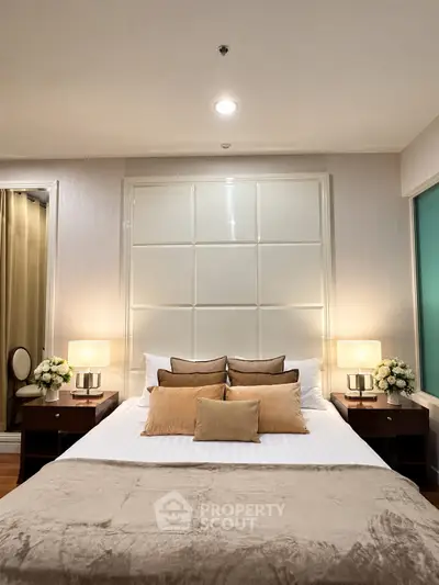 Luxurious bedroom with elegant decor and ambient lighting, featuring plush pillows and bedside tables.