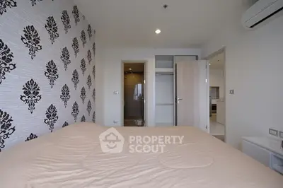 Modern bedroom with stylish wallpaper and open door to bathroom