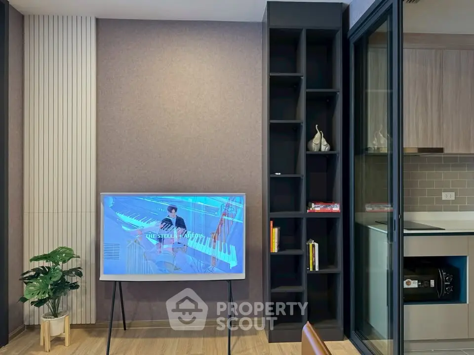 Modern living room with stylish TV setup and sleek kitchen area