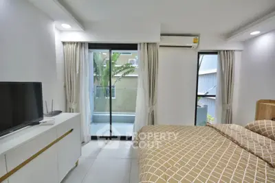 Modern bedroom with balcony access and natural light