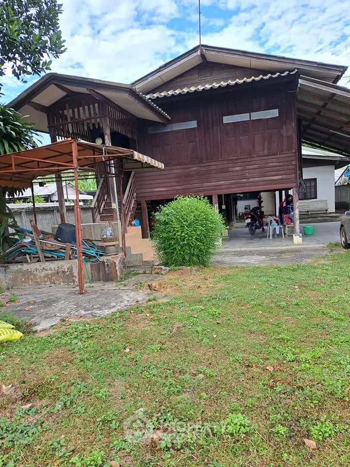 Charming traditional wooden house with lush green garden and spacious outdoor area.