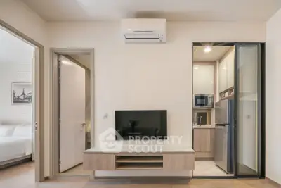 Modern apartment interior with sleek kitchen and cozy living area, featuring built-in appliances and stylish decor.