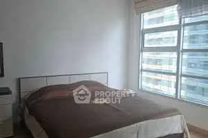 Spacious bedroom with large window offering ample natural light in modern apartment.