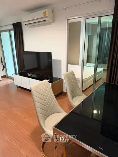Modern apartment interior with sleek dining area and cozy bedroom view.