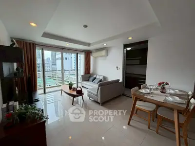 Modern living room with city view, stylish furniture, and dining area in open layout apartment.