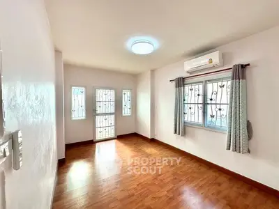 Bright and airy room with wooden flooring and air conditioning, perfect for a cozy living space.