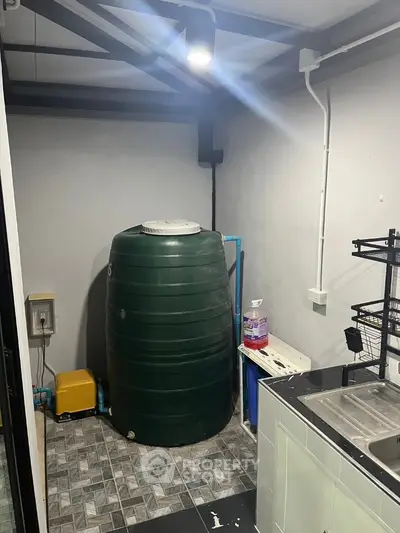 Utility room with water tank and sink in modern home