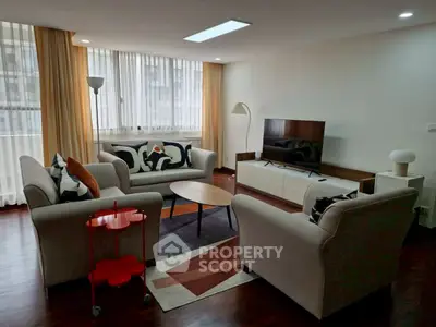 Spacious living room with modern furniture and large windows in a stylish apartment.