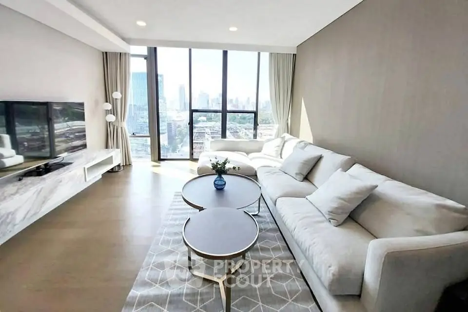 Spacious modern living room with panoramic city view and elegant furnishings.
