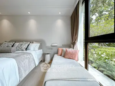 Luxurious bedroom with large window overlooking lush garden, featuring elegant decor and cozy seating area.