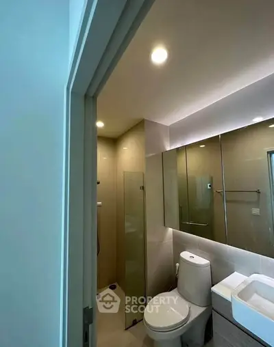 Modern bathroom with glass shower and sleek fixtures in a contemporary apartment.