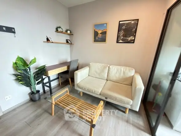 Cozy living room with modern decor, featuring a comfortable sofa, glass coffee table, and stylish wall art.