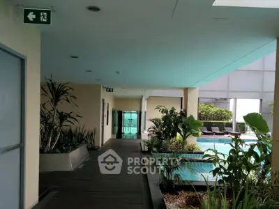 Luxurious apartment building with poolside view and lush greenery