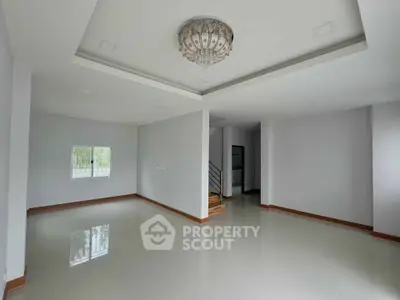 Spacious modern living room with elegant chandelier and glossy tiled flooring