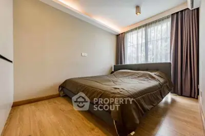 Modern bedroom with cozy lighting and large window in stylish apartment.