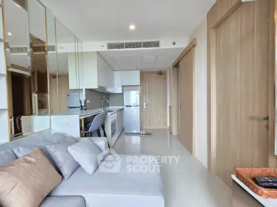 Modern open-layout living room with sleek kitchen and cozy seating area.