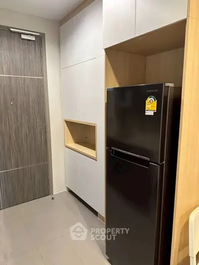 Modern kitchen with sleek black refrigerator and minimalist cabinetry