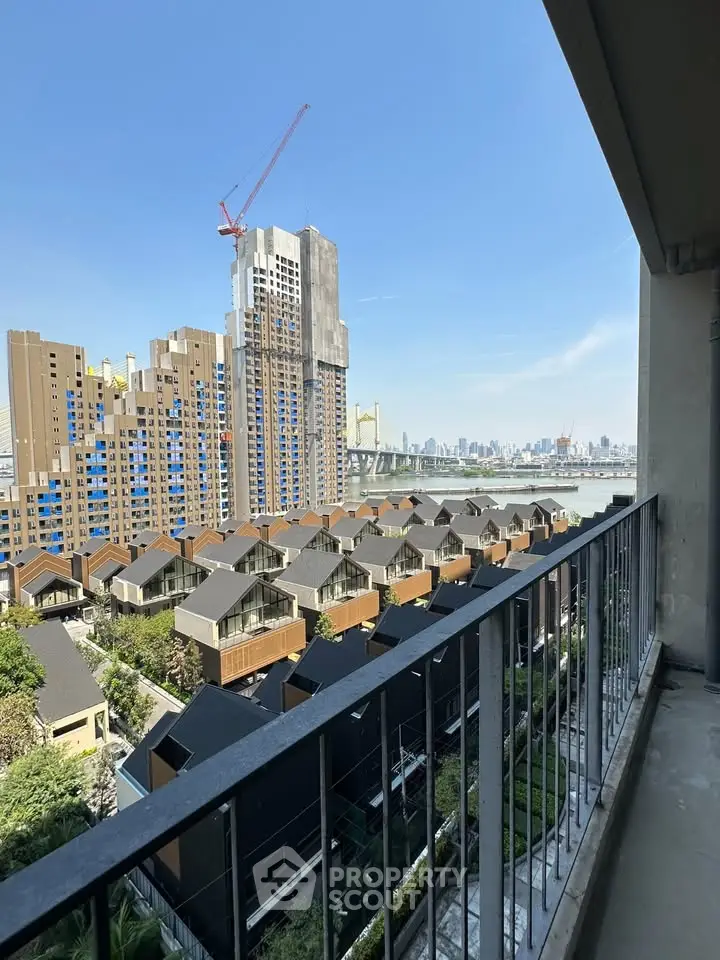 Stunning cityscape view from a high-rise balcony overlooking modern residential area and skyline.