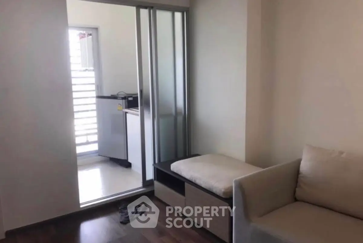 Cozy living room with sliding door leading to a bright balcony area.