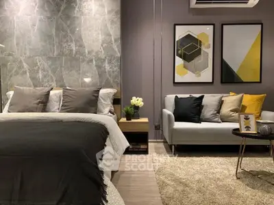 Luxurious bedroom with modern decor, cozy seating area, and stylish artwork, perfect for relaxation and comfort.