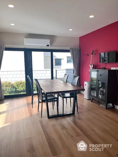 Modern dining area with wooden flooring and large windows in stylish apartment