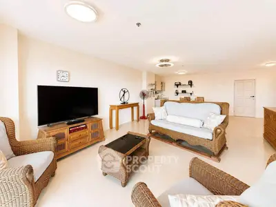 Spacious living room with elegant wicker furniture and modern decor in a bright apartment.