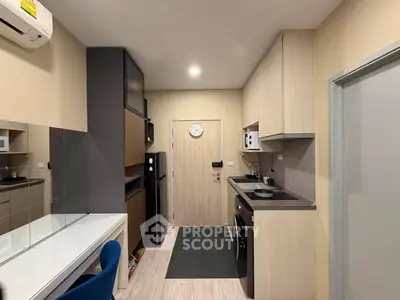 Modern kitchen with sleek cabinetry and integrated appliances in a compact apartment setting.