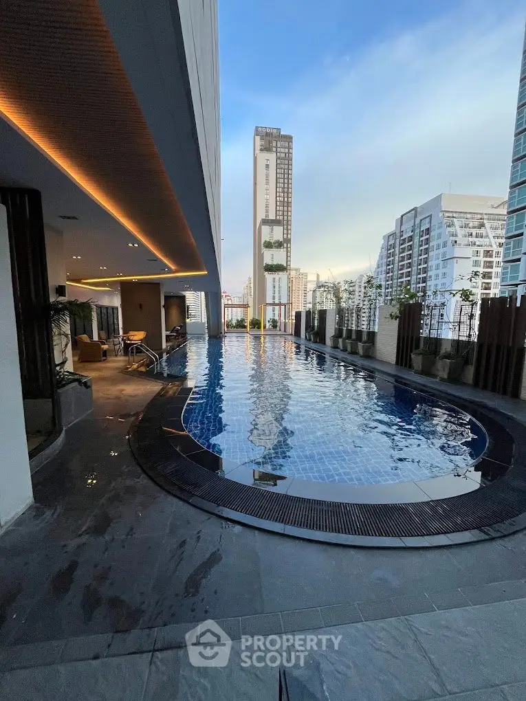 Luxurious rooftop pool with stunning city skyline view in modern high-rise building.