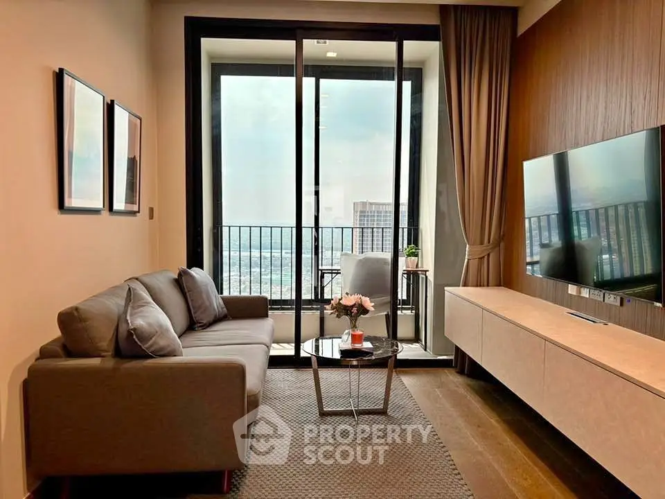 Modern living room with balcony view, stylish furniture, and large TV setup in a cozy apartment.