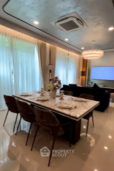 Luxurious open-plan living and dining area with elegant decor and modern lighting.