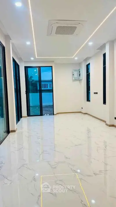 Spacious modern living room with marble flooring and large windows.