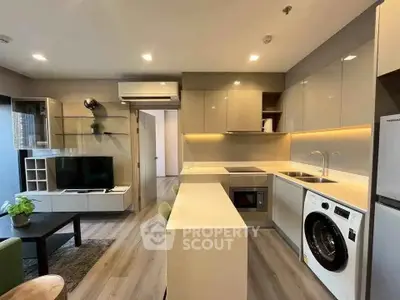 Modern kitchen with sleek cabinetry and integrated appliances in open-plan living area.