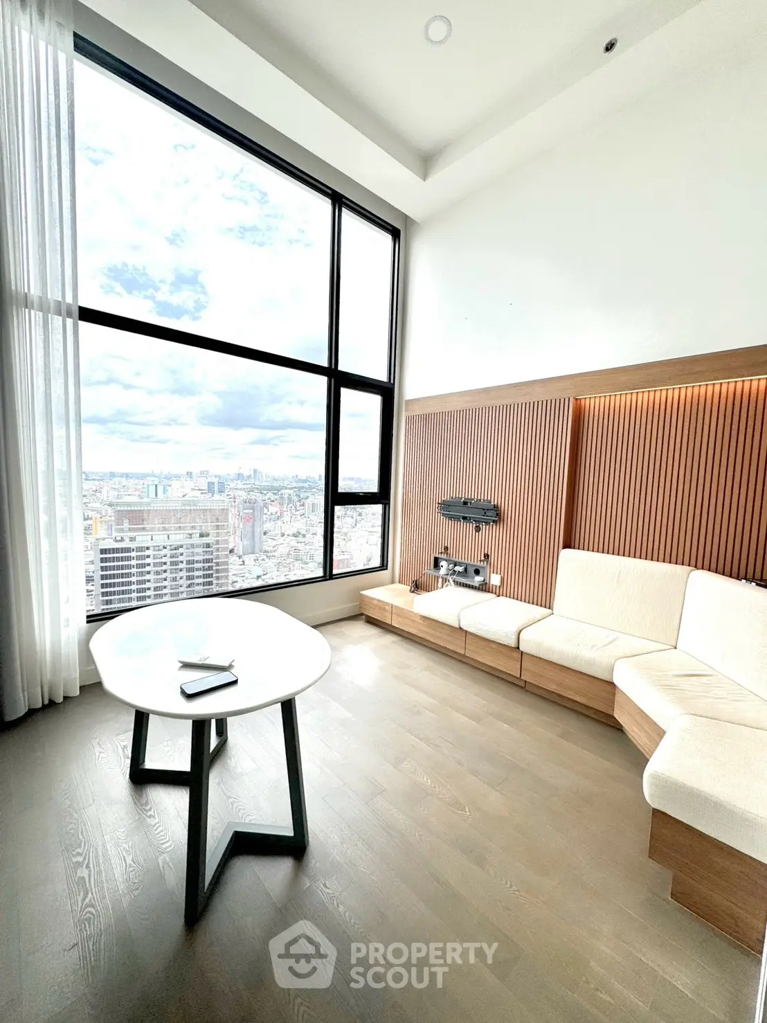 Stunning modern living room with floor-to-ceiling windows and breathtaking city view.