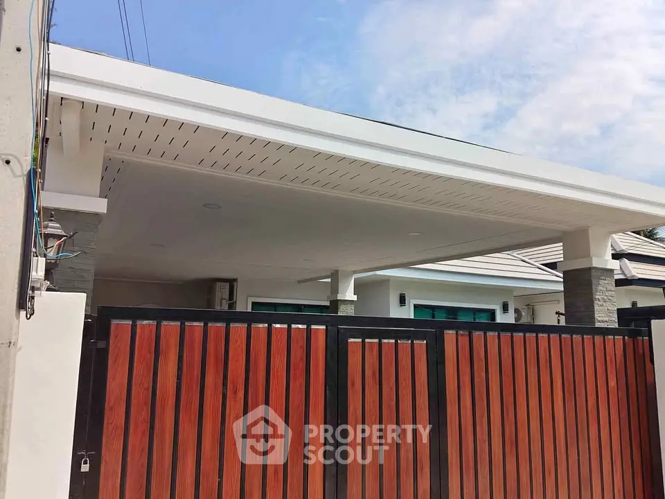 Modern house exterior with stylish wooden gate and sleek roof design