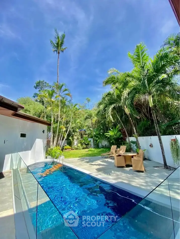 Luxurious outdoor pool area with lush garden and elegant seating, perfect for relaxation and entertainment.