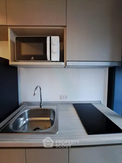 Modern compact kitchen with sleek cabinetry and built-in appliances, perfect for urban living.