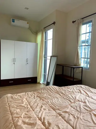 Cozy bedroom with modern wardrobe and natural light, perfect for relaxation.
