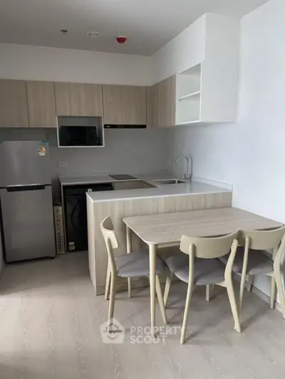 Modern kitchen with sleek wooden cabinets and dining area in a stylish apartment.