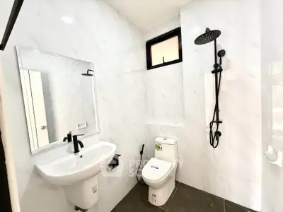 Modern bathroom with sleek fixtures and rainfall showerhead in a contemporary real estate property.