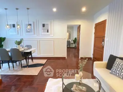 Elegant living room with dining area, modern decor, and wooden flooring.