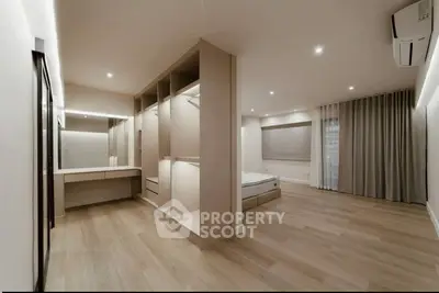 Spacious modern bedroom with wooden flooring and built-in wardrobe