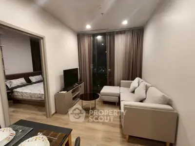 Modern living room with cozy sofa and city view, adjacent to a stylish bedroom.