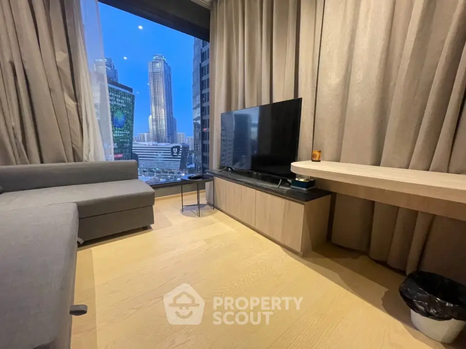 Modern living room with city view, featuring sleek furniture and large windows.