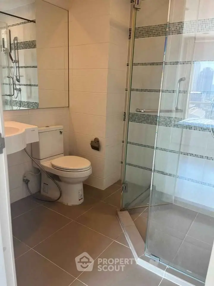 Modern bathroom with glass shower and sleek fixtures in a contemporary apartment.