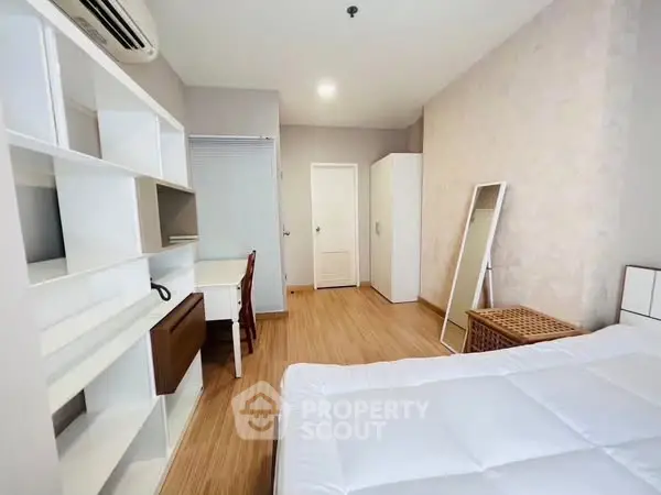 Spacious bedroom with modern furnishings and ample storage in a cozy apartment.